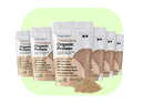 Bags of Complements 6x Chocolate Protein are lined up, showcasing their beige and white packaging. Ingredients like almond, coconut, pumpkin seed, sunflower seed, and yellow pea are featured. A small mound of the protein powder is in the foreground.