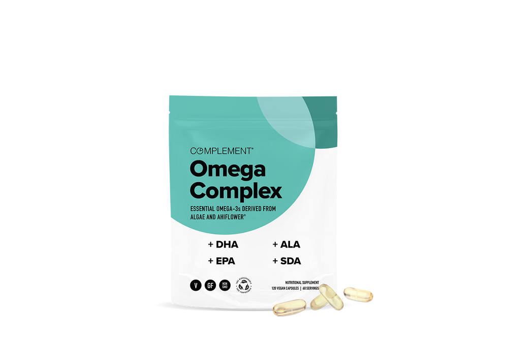 A teal and white package labeled Complement Omega Complex with text highlighting DHA, EPA, ALA, and SDA. Four yellowish capsules are placed in front of the package on a white background.