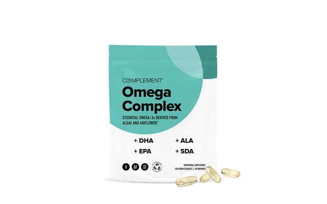 A teal and white pouch labeled Complement Omega Complex stands upright, with Omega-3 capsule supplements scattered in front. The packaging highlights DHA, EPA, ALA, and SDA as key ingredients.