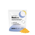 A white pouch labeled “COMPLEMENT® Restore” from Complement stands upright, with a yellow and blue circular design. The text highlights magnesium for restorative sleep and cellular recovery. Orange powder lies beside the package.