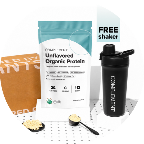 A bag of Complement Unflavored Organic Protein powder, a black shaker, and a scoop of powder are displayed on a white surface. Text reads “FREE shaker.” A brown box is partially visible in the background.
