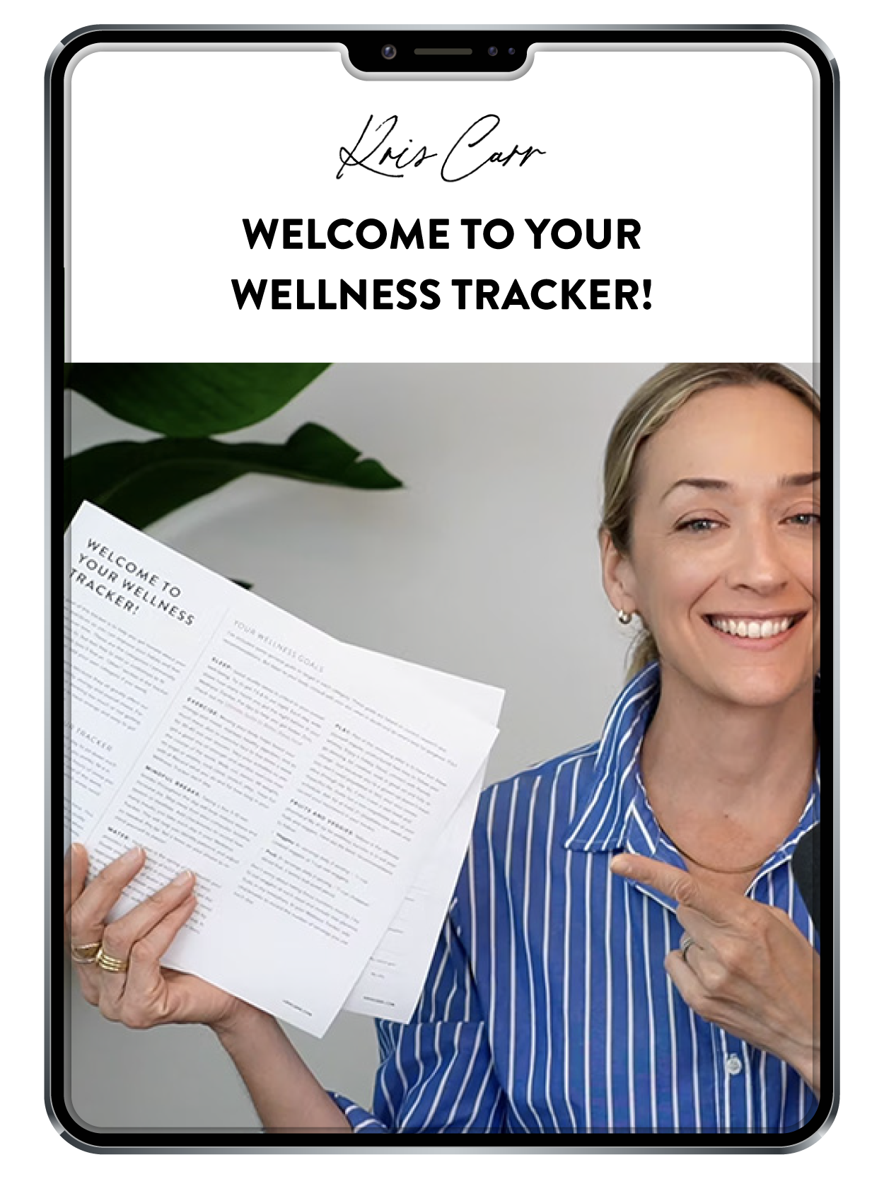 A smiling woman in a blue striped shirt holds and points to a booklet titled Welcome to Your Wellness Tracker! while standing in front of a plain background, displayed on a tablet screen.