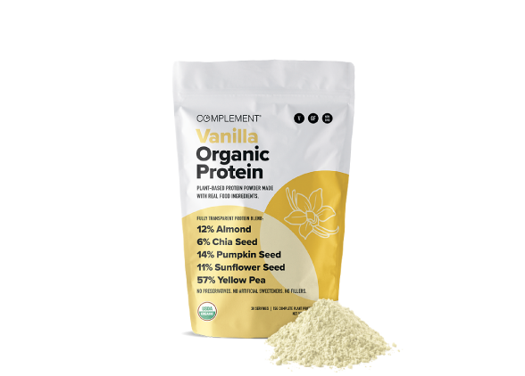 A bag of Complement Vanilla Organic Protein powder with a yellow and white label, listing ingredients such as almond, chia seed, pumpkin seed, sunflower seed, and yellow pea. A pile of the protein powder is in front of the bag.
