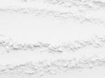 Loose white powder is arranged in several uneven, horizontal lines on a white surface, creating a textured pattern across the image.