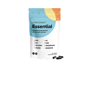 A white and blue resealable pouch labeled Complement Essential with orange accents, next to three black capsules. The package lists nutrients like B12, D3, DHA/EPA, iodine, K2, zinc, magnesium, and selenium.