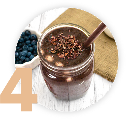 A jar of dark smoothie topped with cacao nibs and a straw sits on a wooden surface. A small white dish filled with blueberries is in the background. A large number 4 is in the foreground.
