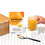 A hand holds a glass of orange beverage next to a packet labeled Gut Nurture and a black spoon filled with powder, all placed on a white, dotted surface with a cardboard box in the background.