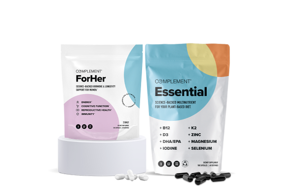 Two supplement packages on display. The first is labeled ForHer with a focus on immunity, cognitive function, and reproductive health. The second is labeled Essential, highlighting nutrients like B12, D3, K2, Zinc, and more. Capsules are scattered in front.