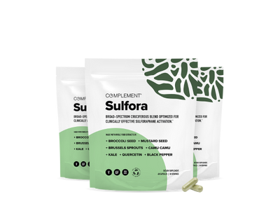 Three standing pouches of Complement Sulfora supplements with green leafy graphics on white packaging. Two capsules are placed in front of the rightmost pouch. Product highlights and ingredients are listed on the packages.