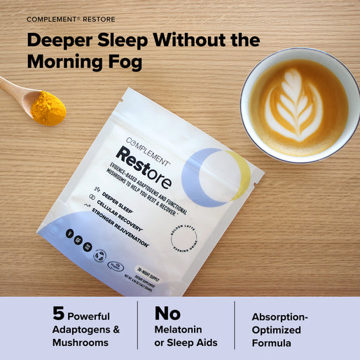 A COMPLEMENT® Energy Stack packet from Complement, a latte with latte art, turmeric powder, and text highlighting deeper sleep benefits, adaptogens, no sleep aids, and an optimized formula are arranged on a wooden table.