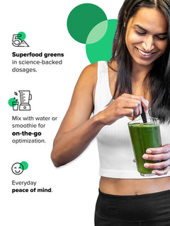 Image of vegan woman holding a glass of Complement Daily Greens powder mixed with water