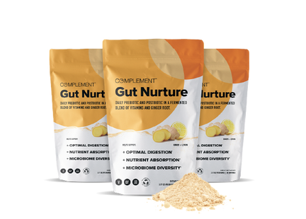 Three bags of Complement Gut Nurture supplement with lemon and ginger illustrations, highlighting benefits such as optimal digestion, nutrient absorption, and microbiome diversity. A small pile of the powdered product is in front.